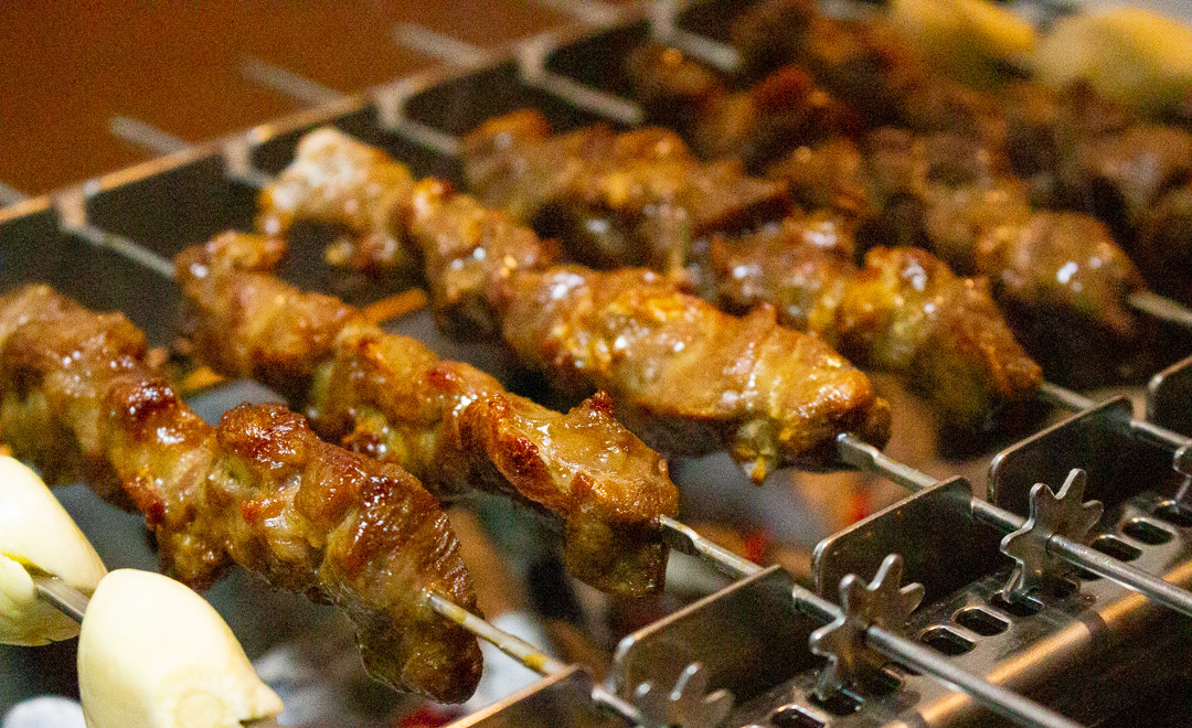 Yangbokjeom lamb skewers sizzling over charcoal with cumin aroma