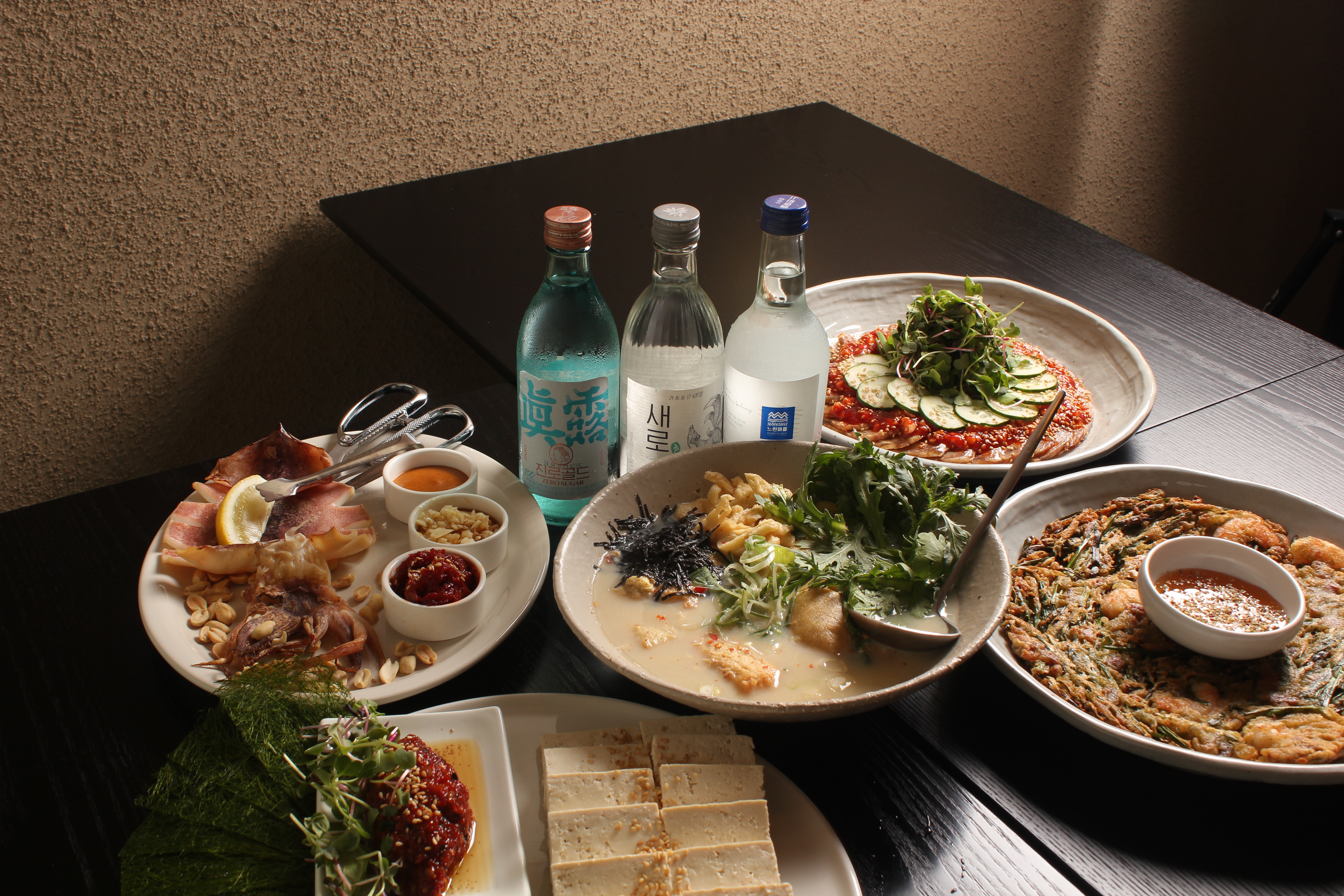 따로집 マッコリバーの木製テーブルと韓国小皿料理