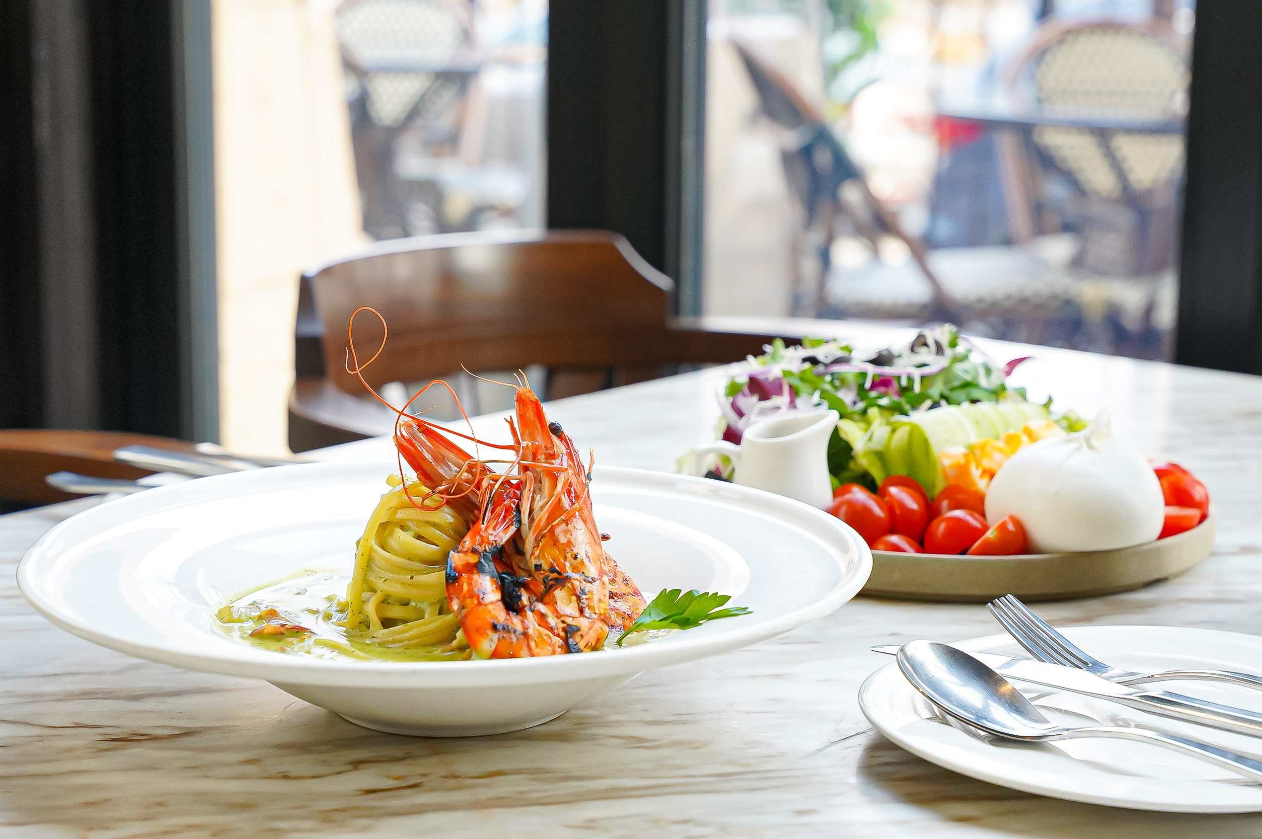 カトルンビー ヤンジェ店の高い天井と大きな窓のブランチホール