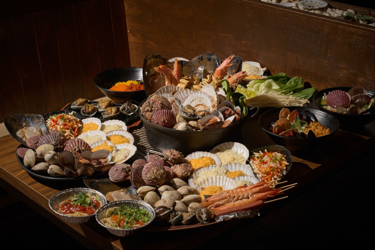 Jjogaeのスタッフがテーブルで貝を焼く