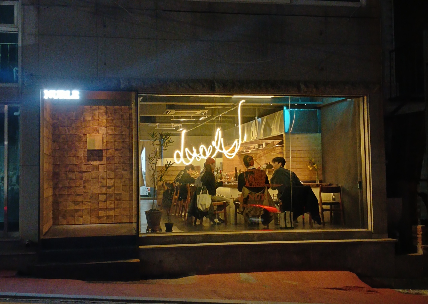 Nurle oak wood-fired dining bar interior with soft glow
