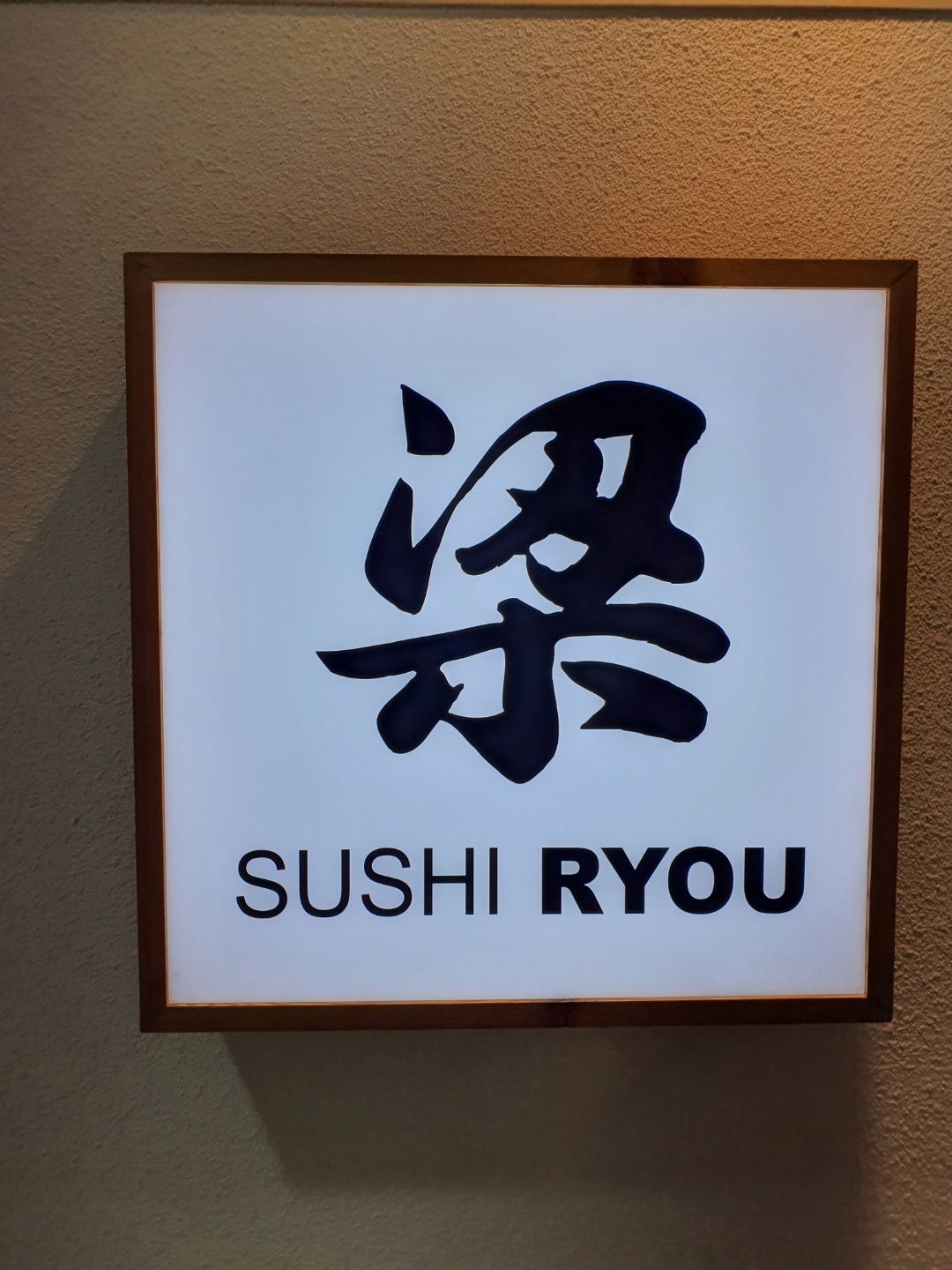 Wine glass and sushi at an omakase counter in Incheon