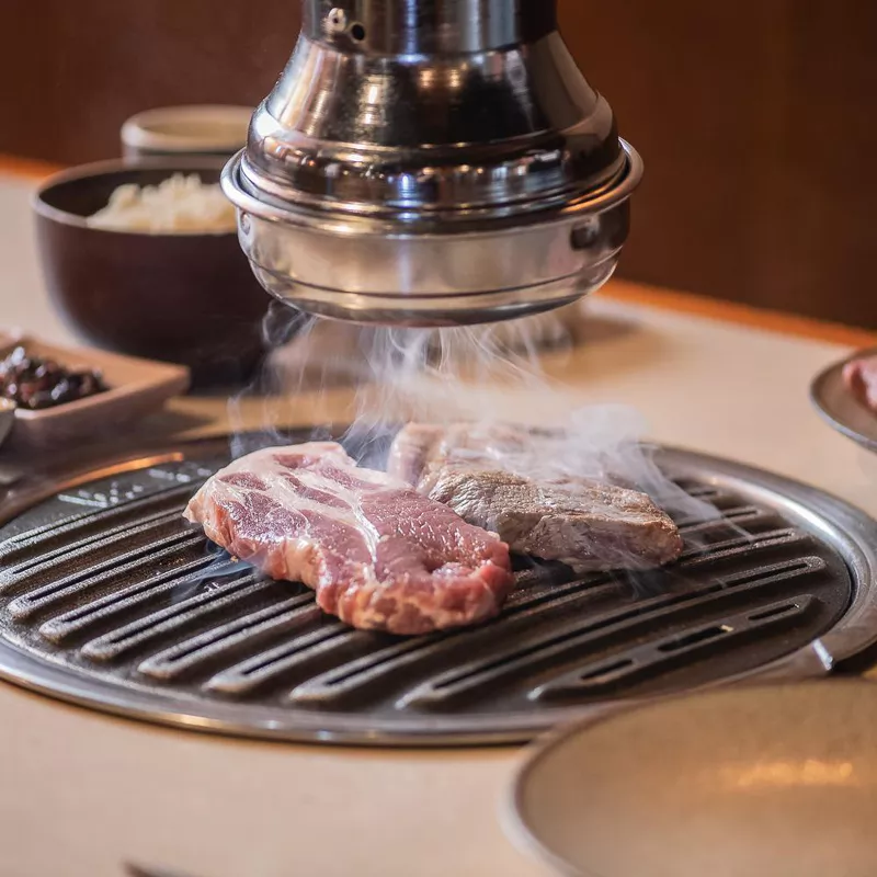 Ggupdang Sinsa pork shoulder searing on hot grill