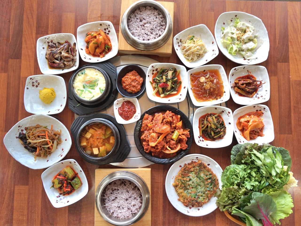 Gomokjeong Ssambap Wangsan platters with leafy wraps and spicy pork