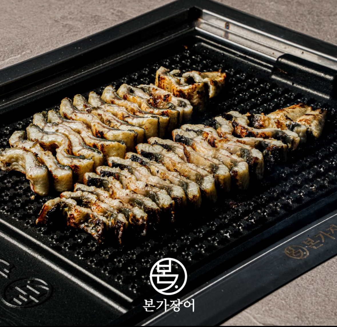 Thick Korean freshwater eel being grilled at the table in Sinsa