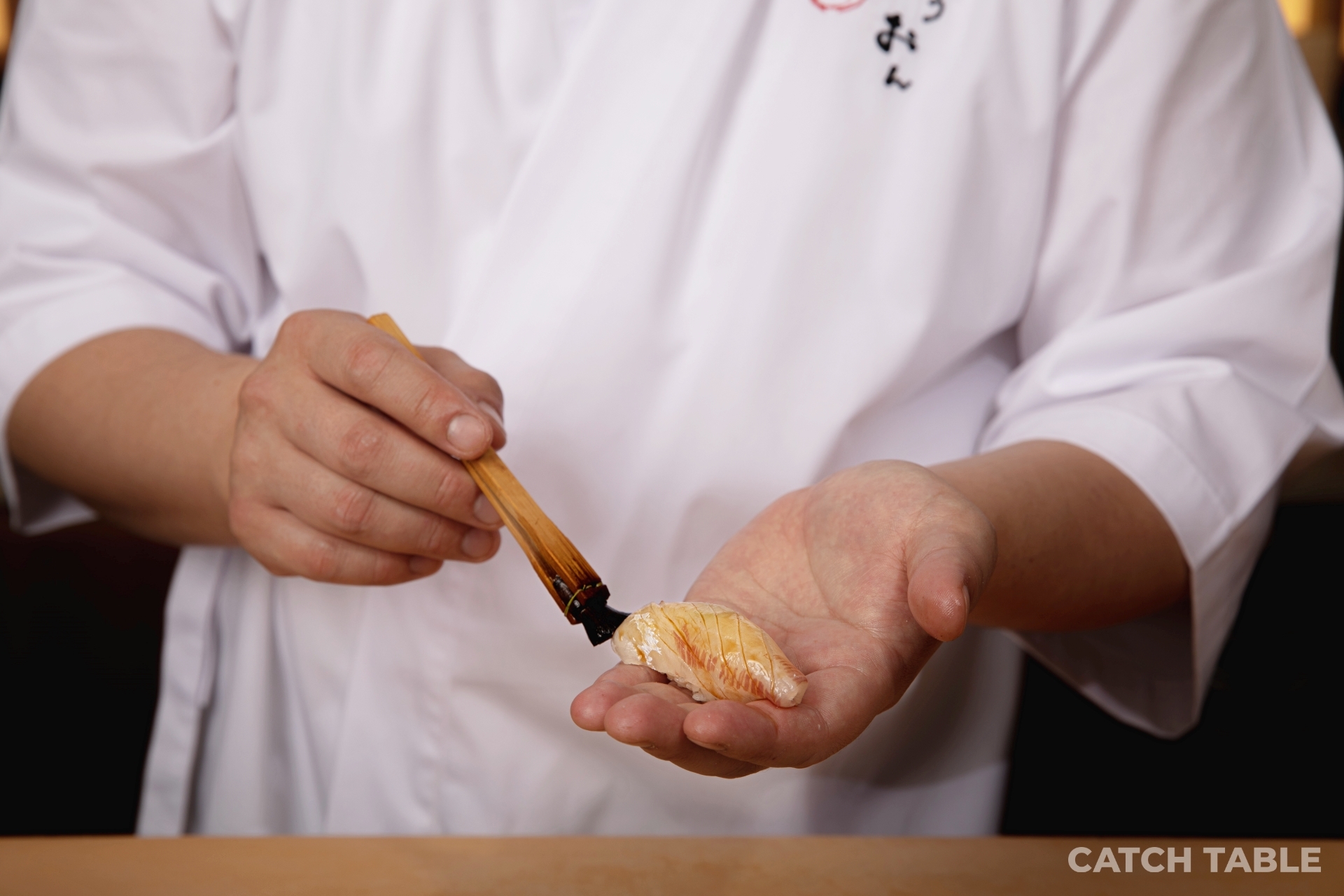 SUSHI DAWNのおまかせカウンターと柔らかな街の灯り