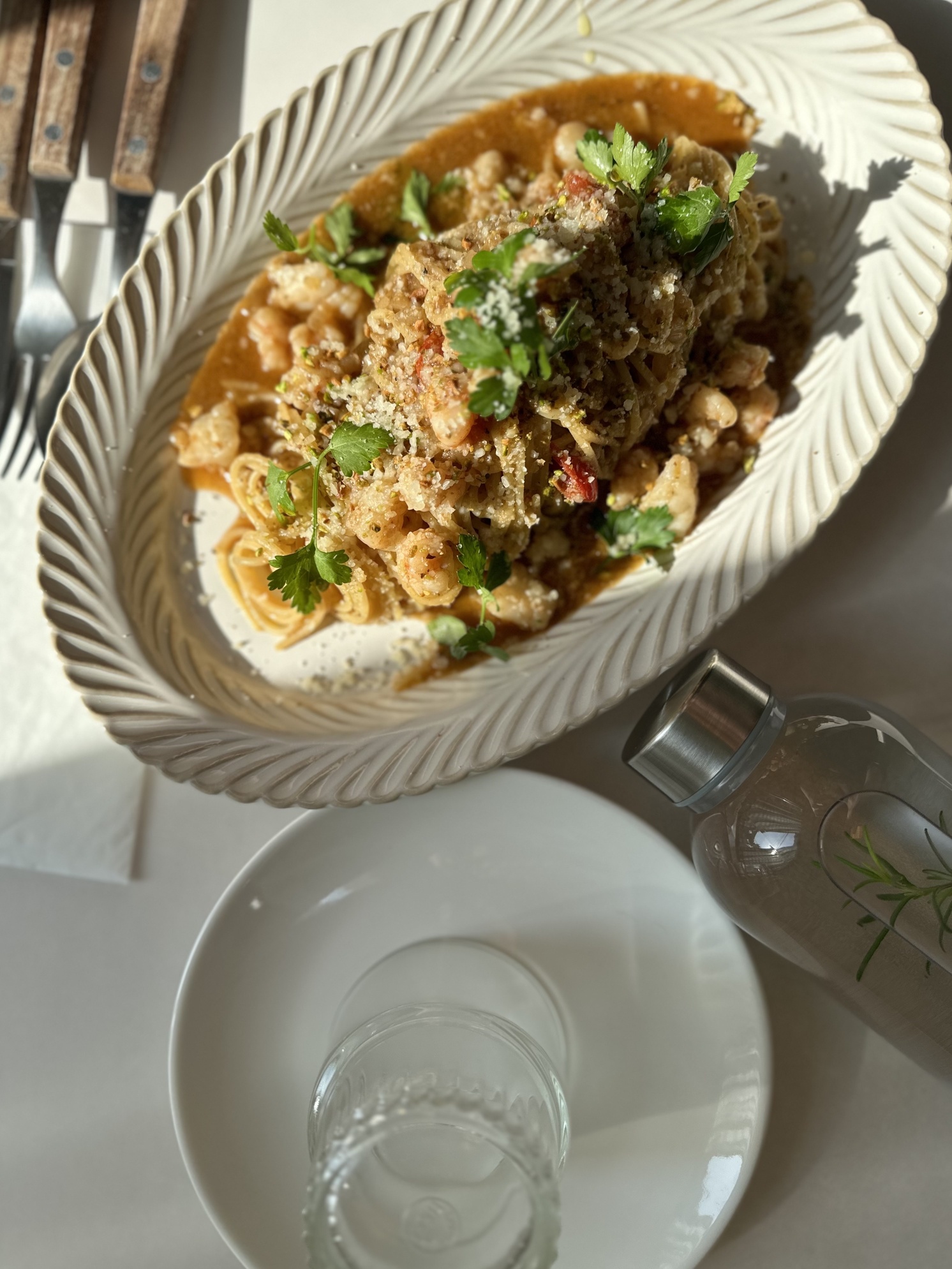 Warm-lit bistro table at Normal Kitchen Hyehwa with pasta and wine