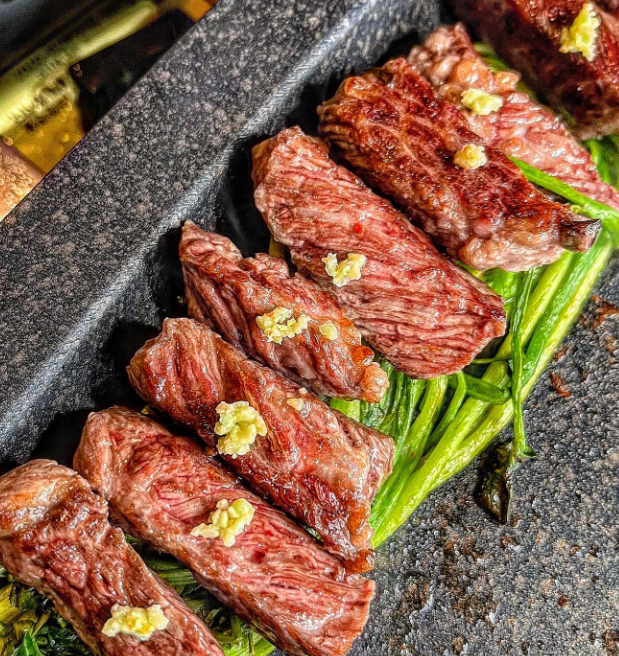 弘大森林の小径沿いの窓辺で豚肉と牛肉を焼くスタッフの様子