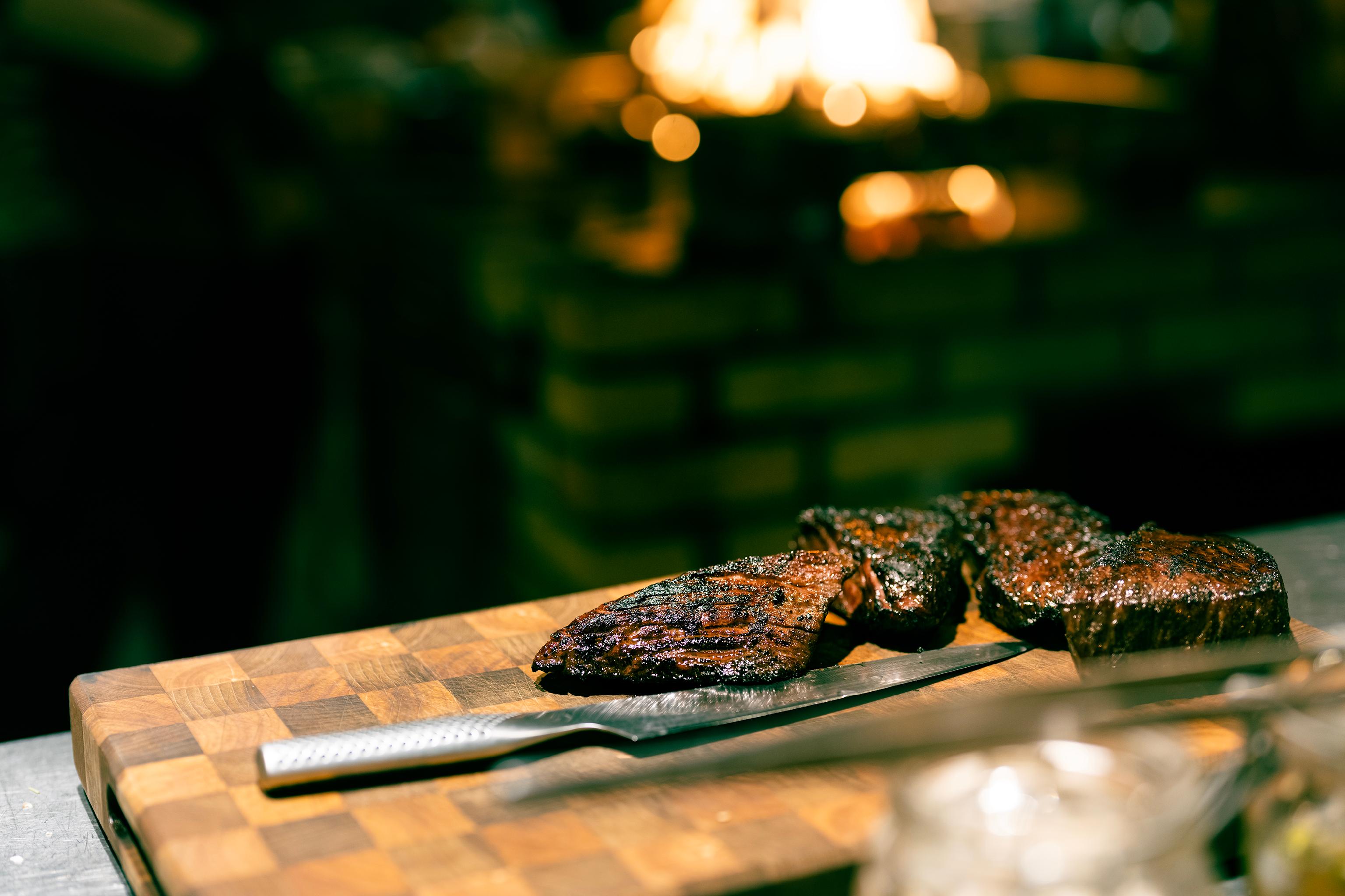 Ox Live Fire Grill charcoal flames and seasonal plates