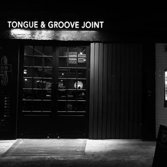 Tongue & Groove Joint 熟成肉於烤架上滋滋作響，溫馨酒吧燈光下