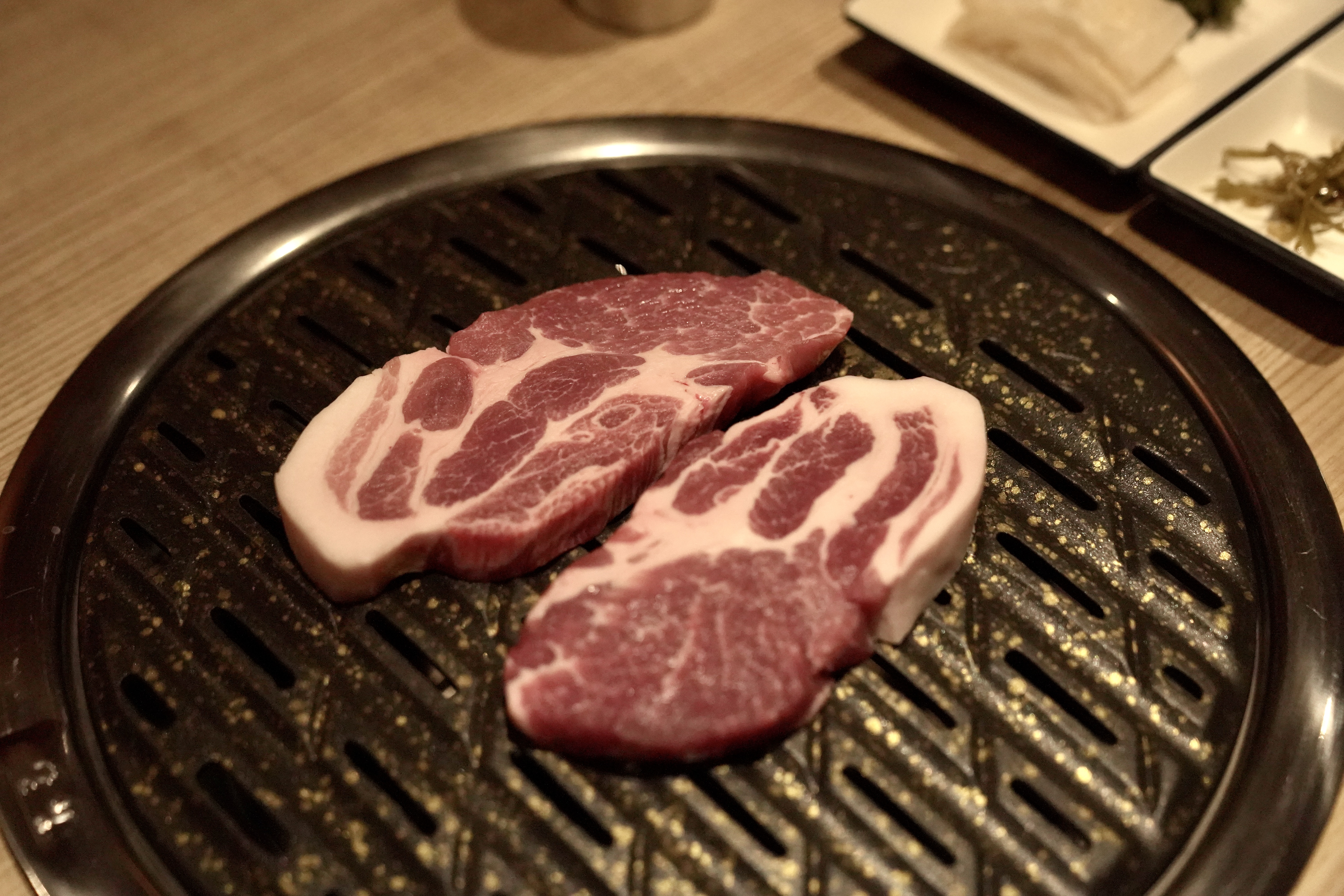 1PIG charcoal grill with cross-aged pork sizzling over embers