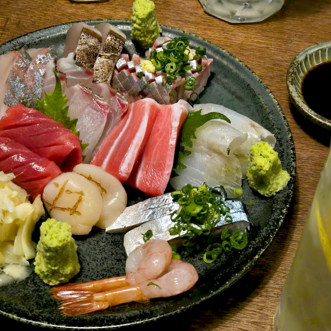 Mokuren izakaya counter and sashimi plating in warm light