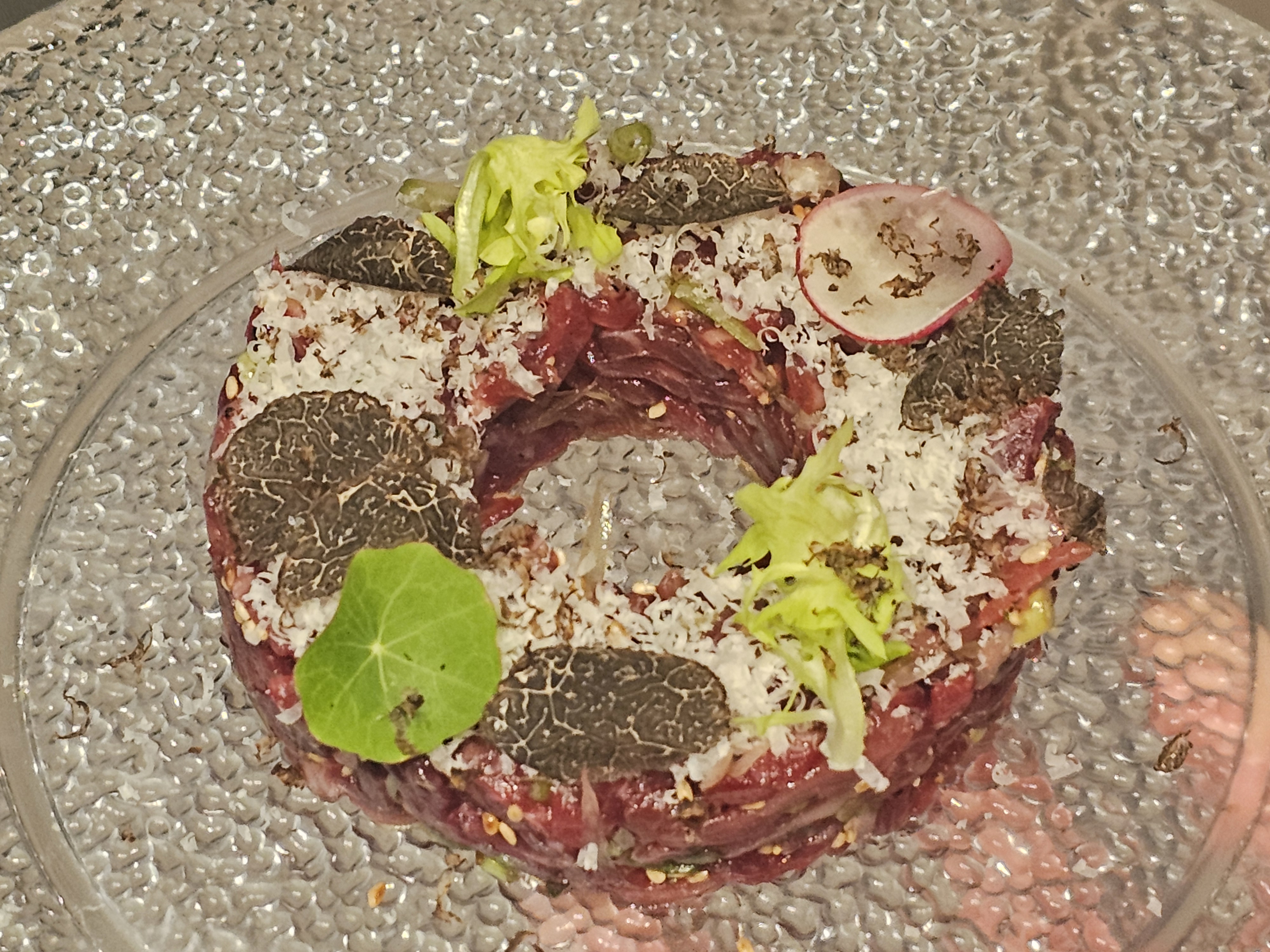 大邱摆盘菜品旁闪烁的酒杯光芒