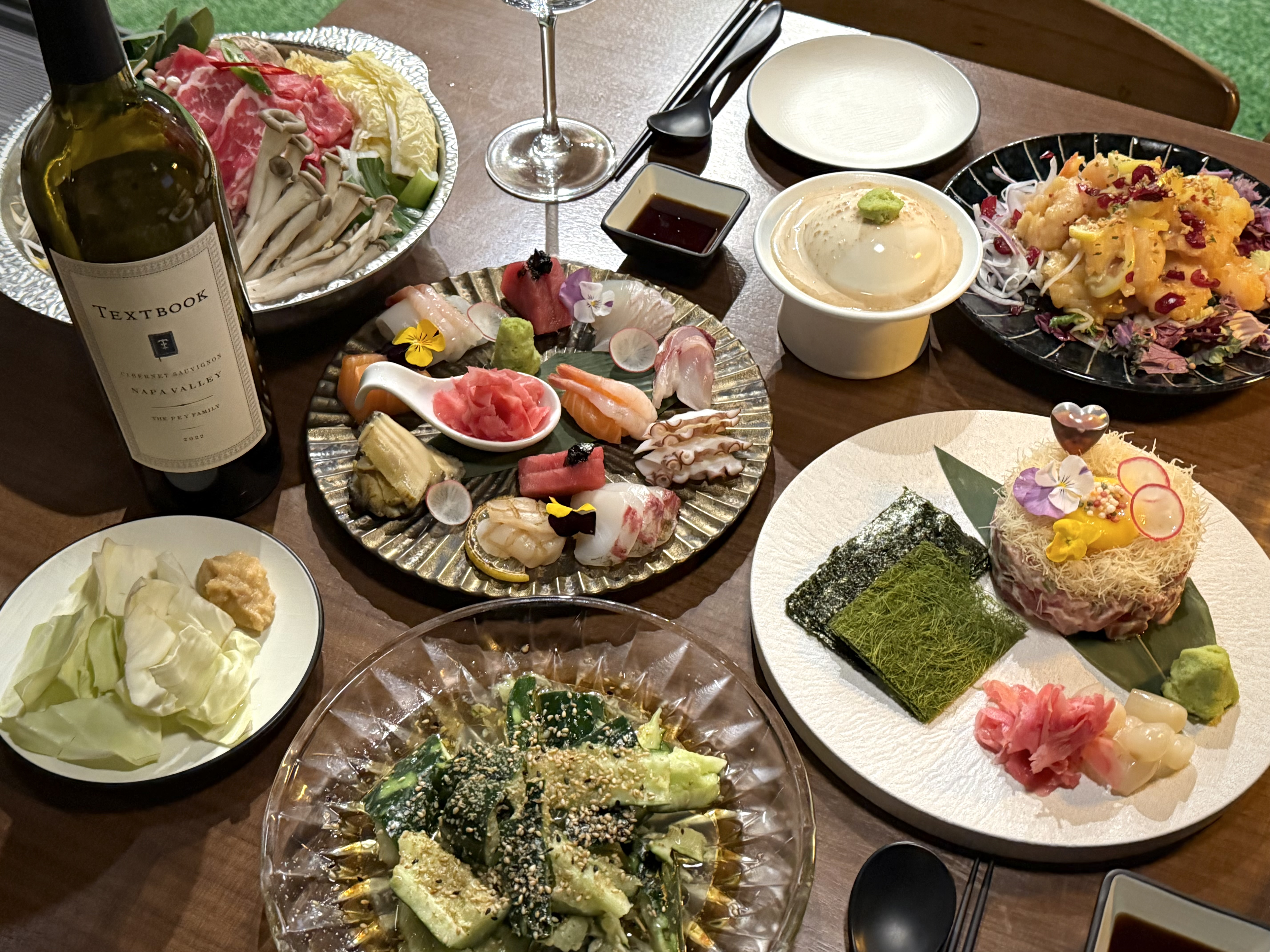 浸染暖黄灯光的JUN居酒屋新沙店吧台与菜肴