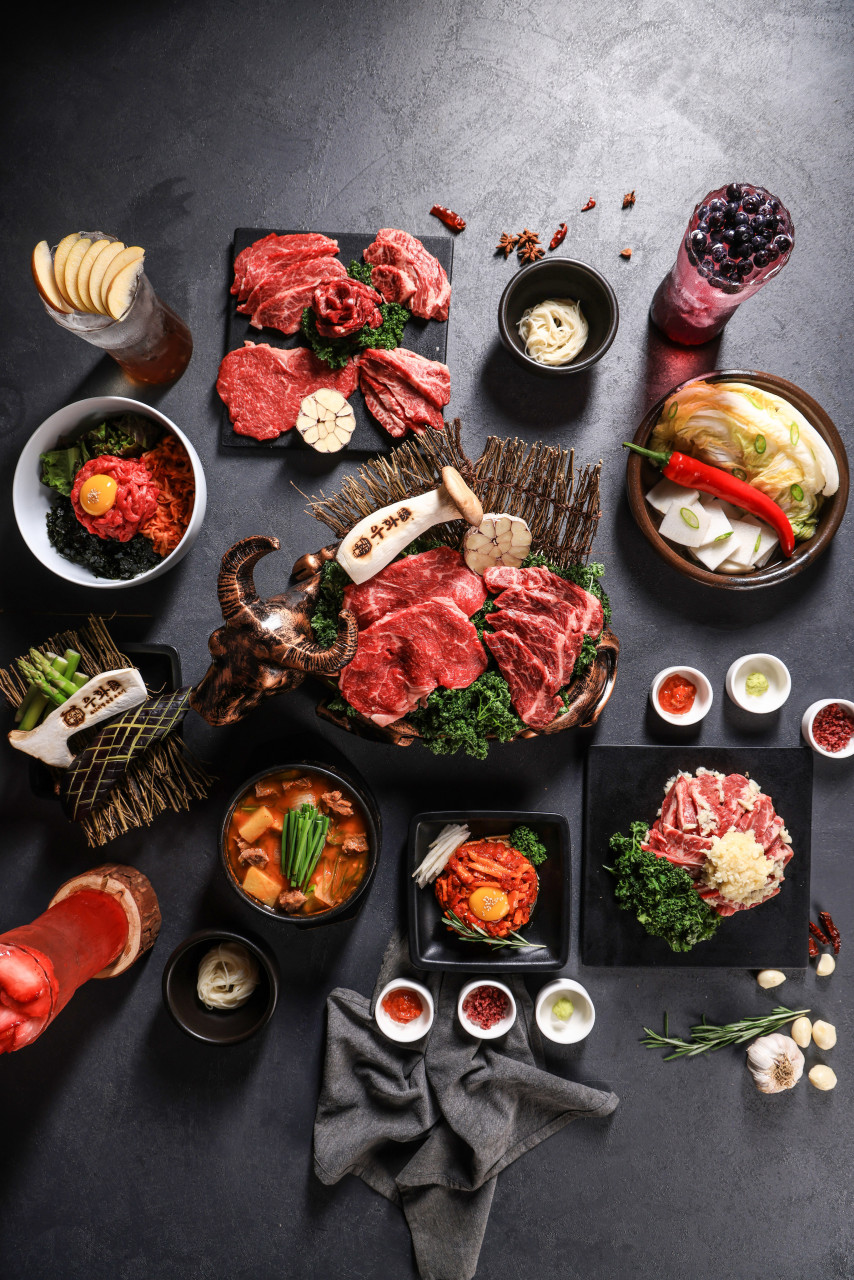 woohwa弘大本店のスタッフが焼くグリルと整えられたおかず