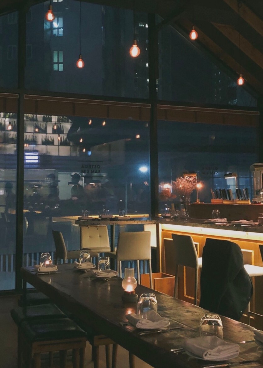 Warm-lit dining room and rustic Italian plates at Osteria Sam Kim - Image 6