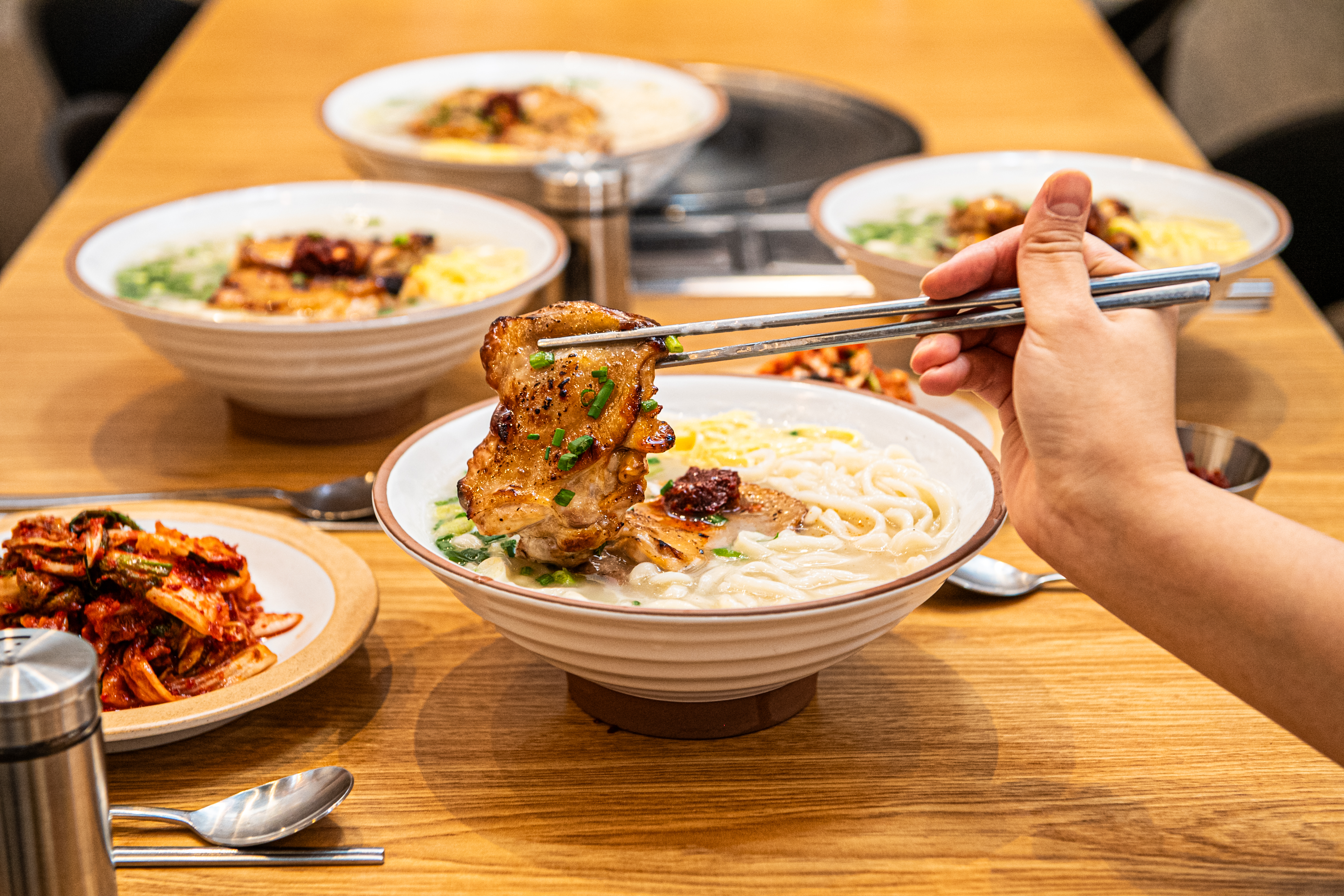 Grilled chicken piled over steaming chicken noodle soup