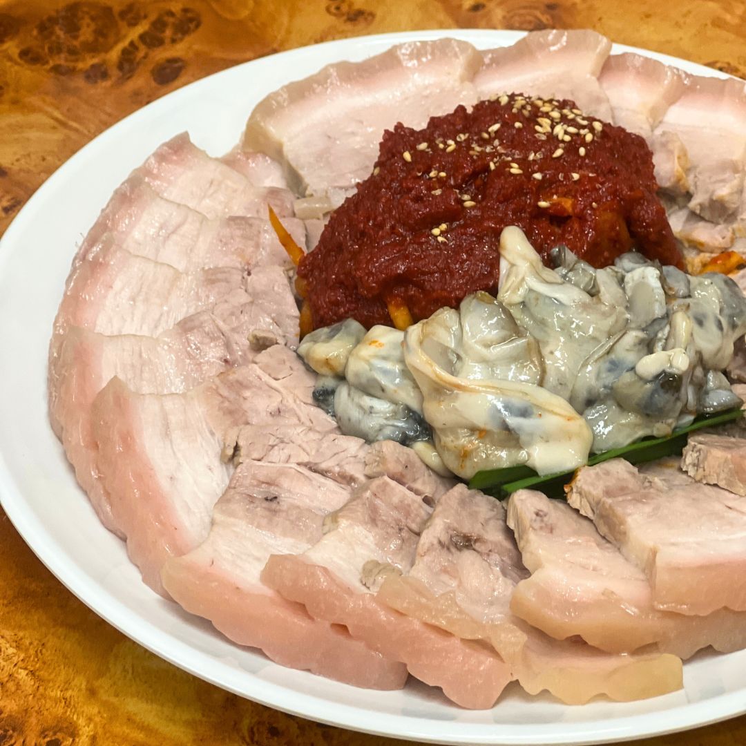 Bright Light Noodle Euljiro with large bowls of cold buckwheat noodles and side dishes