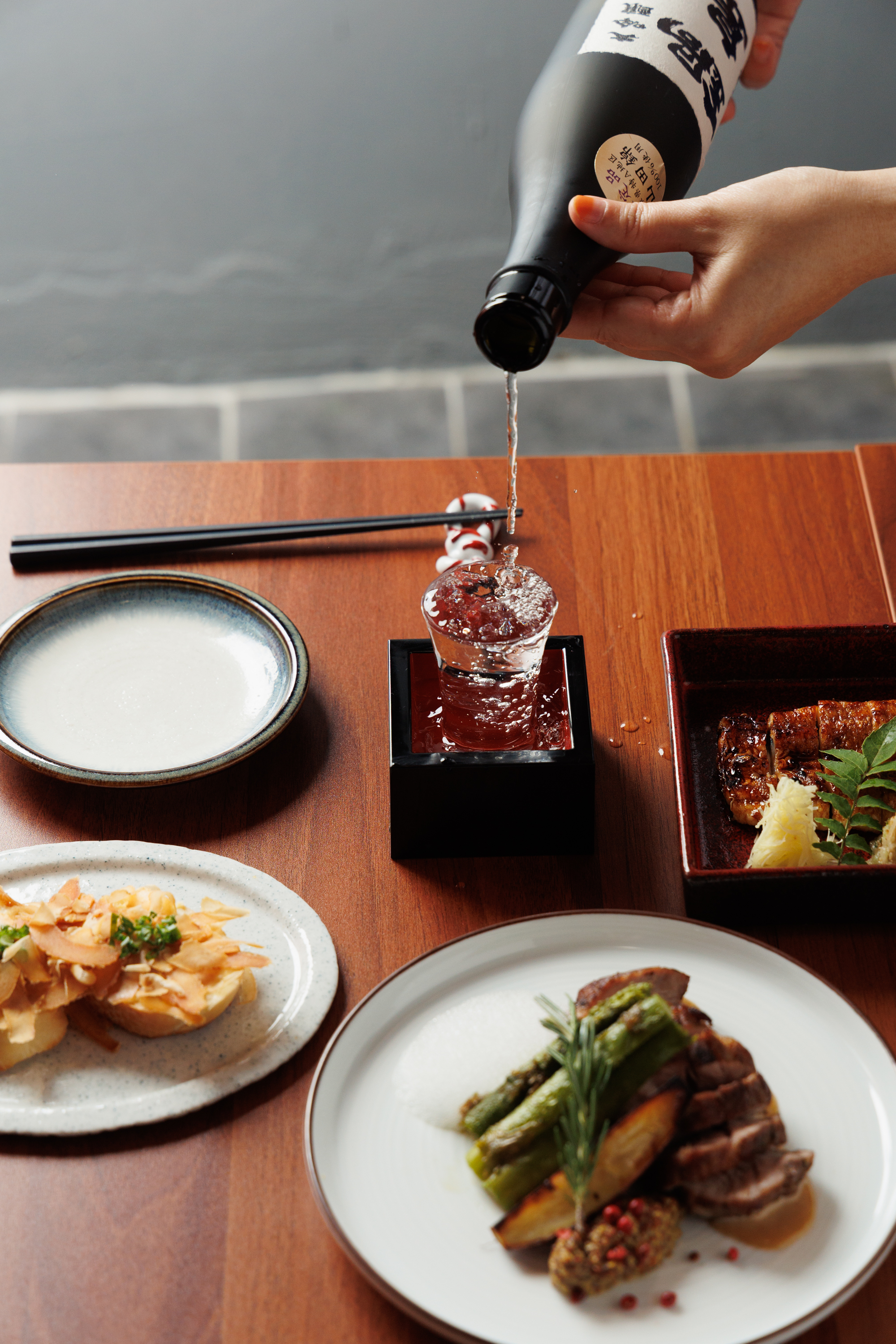 THE HAND cozy counter with sake bottles and small plates