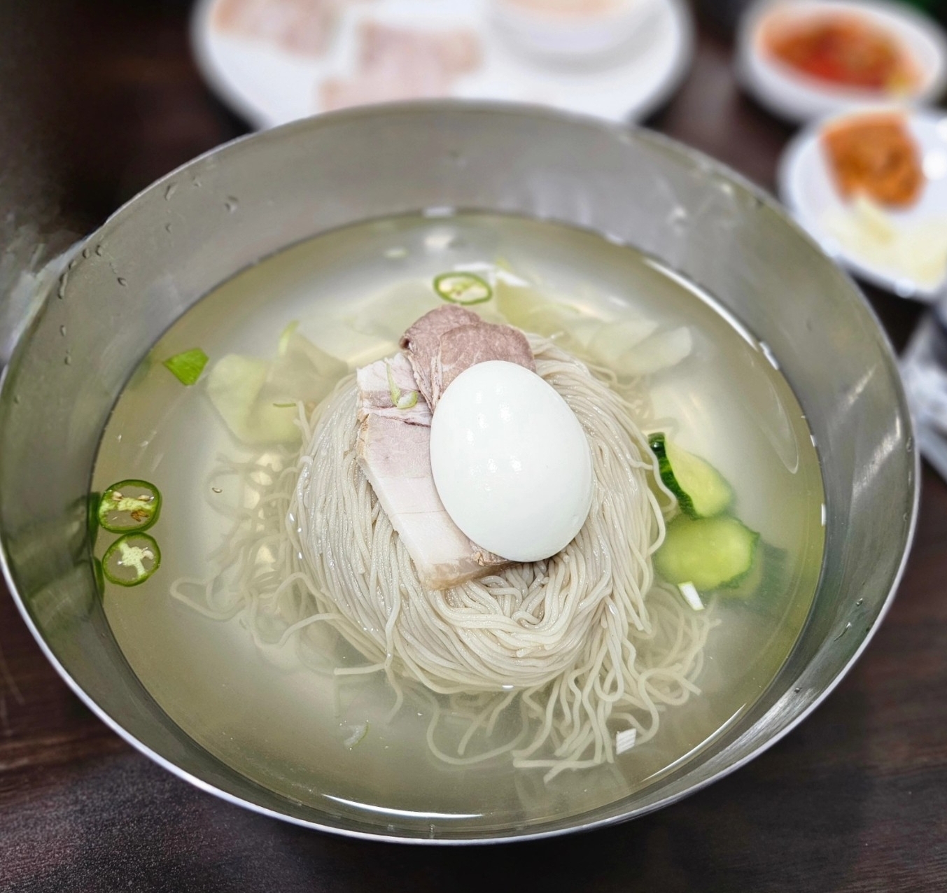 Crystal-clear Pyongyang cold noodle broth with buckwheat noodles at Baekil
