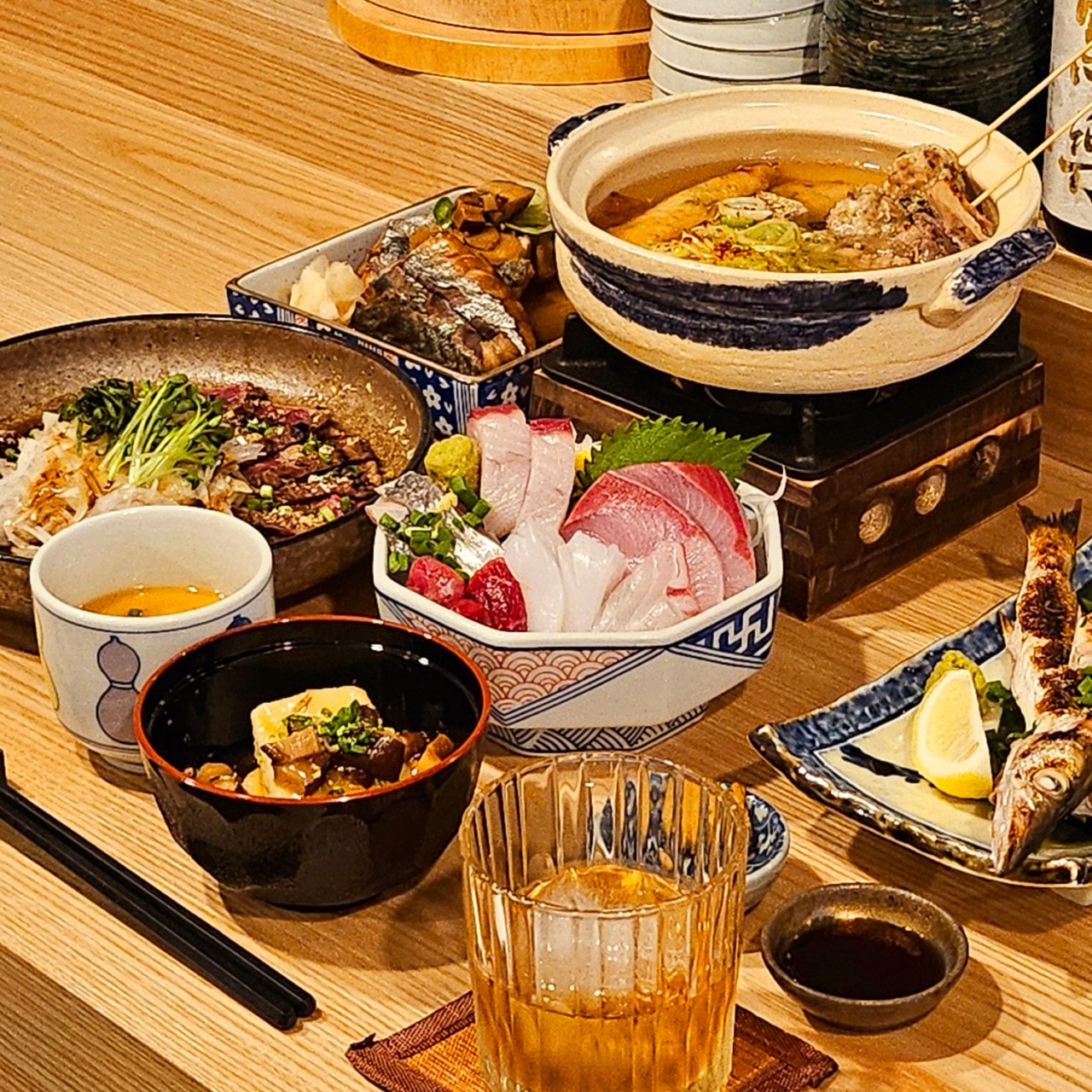 Sigdang Kyumの半地下居酒屋カウンターに並ぶ熟成刺身と酒